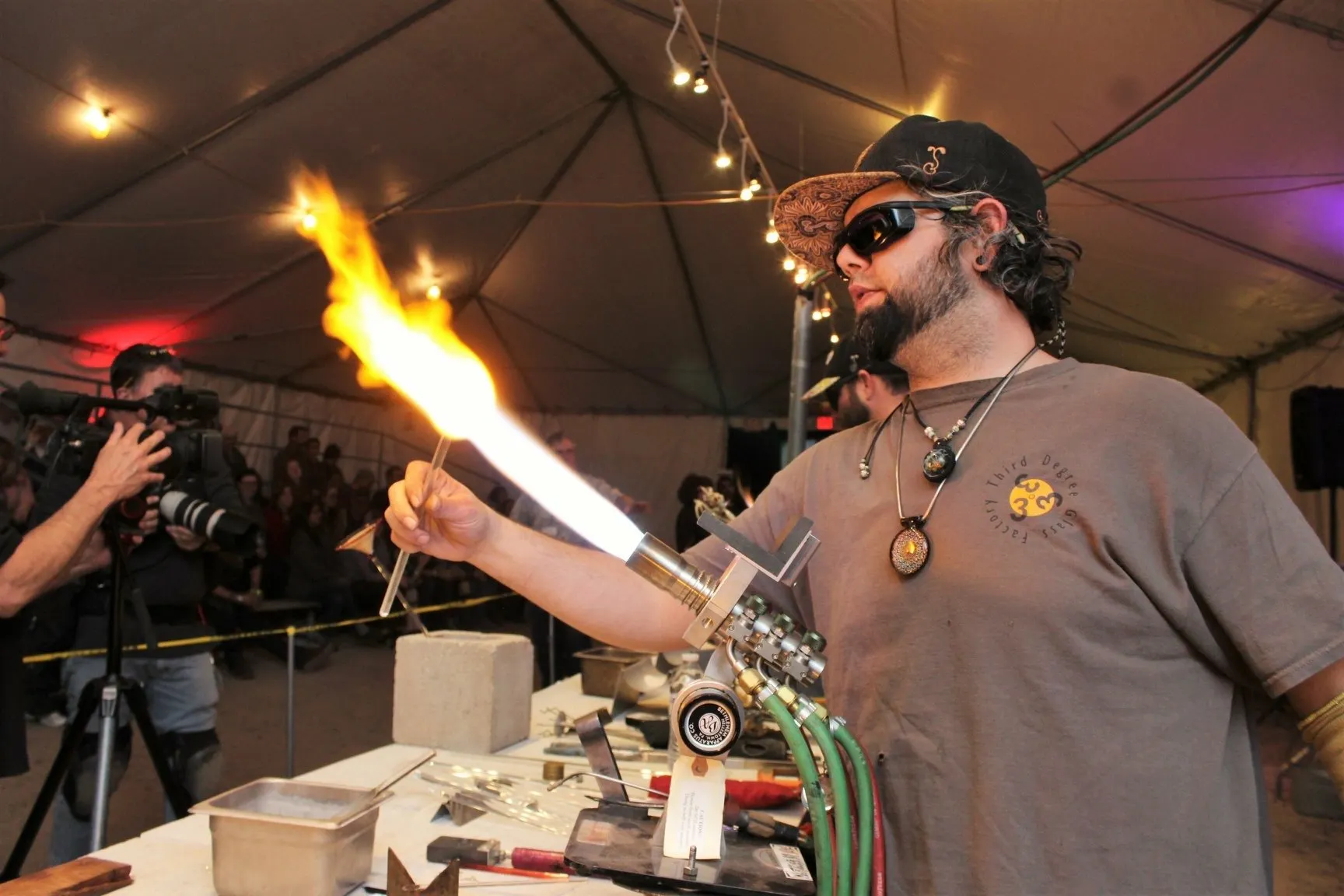 man blowing glass marble with torch