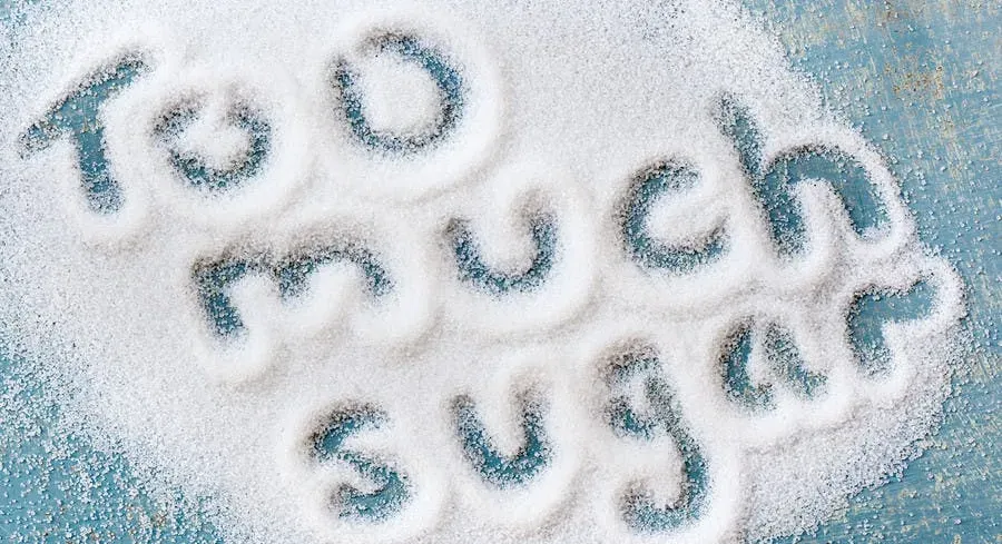 a table full of sugar with the words "too much sugar" carved out.