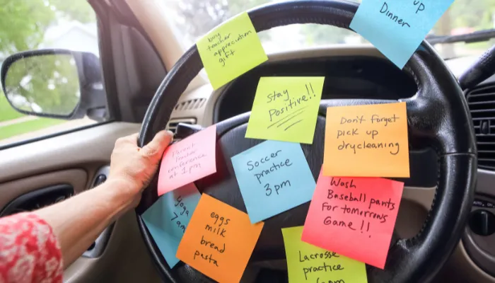 A mom with a ton of post-it notes on her steering wheel.