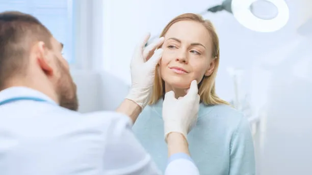 male physician examining a female patients face