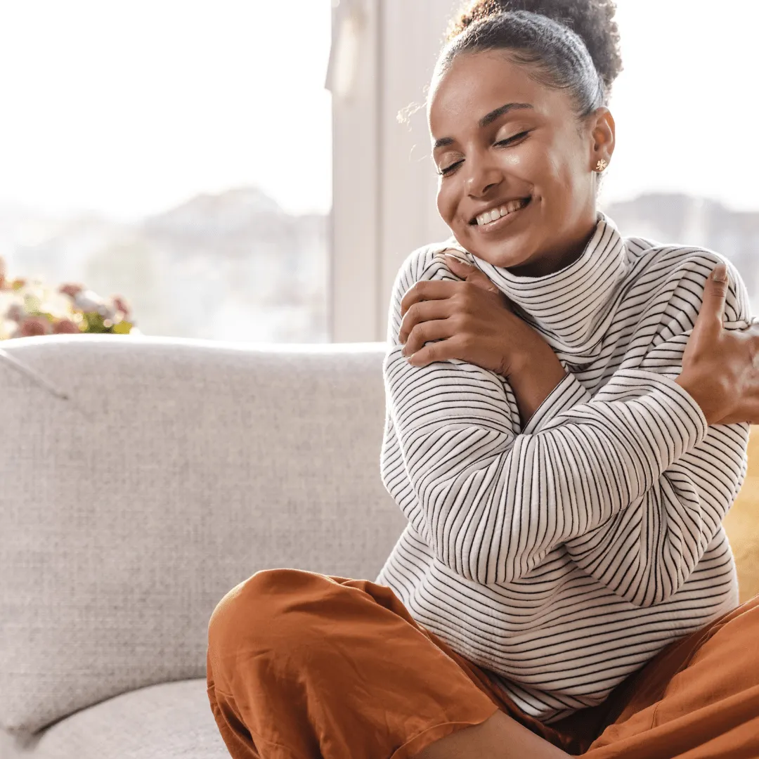 A woman embracing herself feeling self-love. 