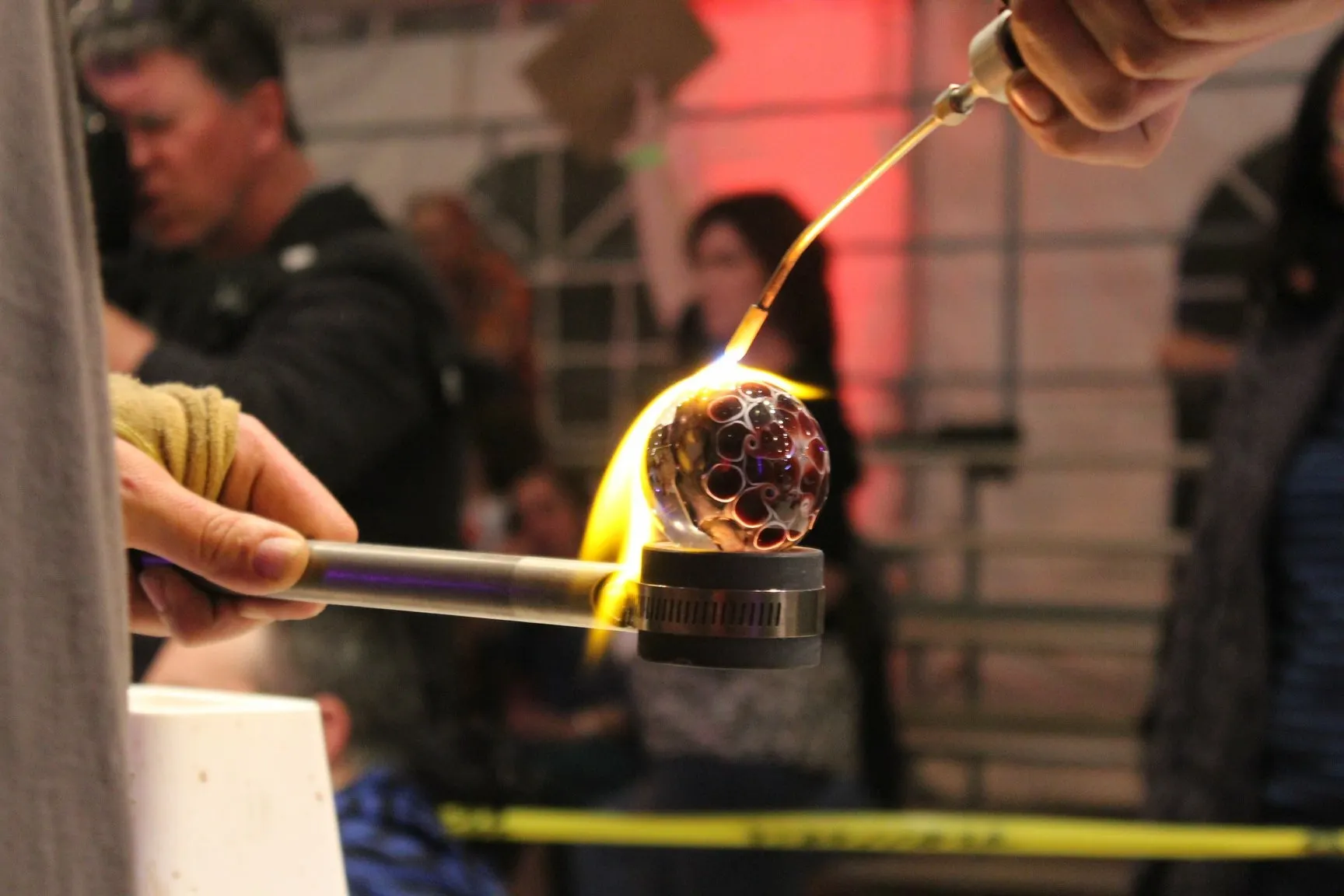 up close image of a glass marble being formed by a torch