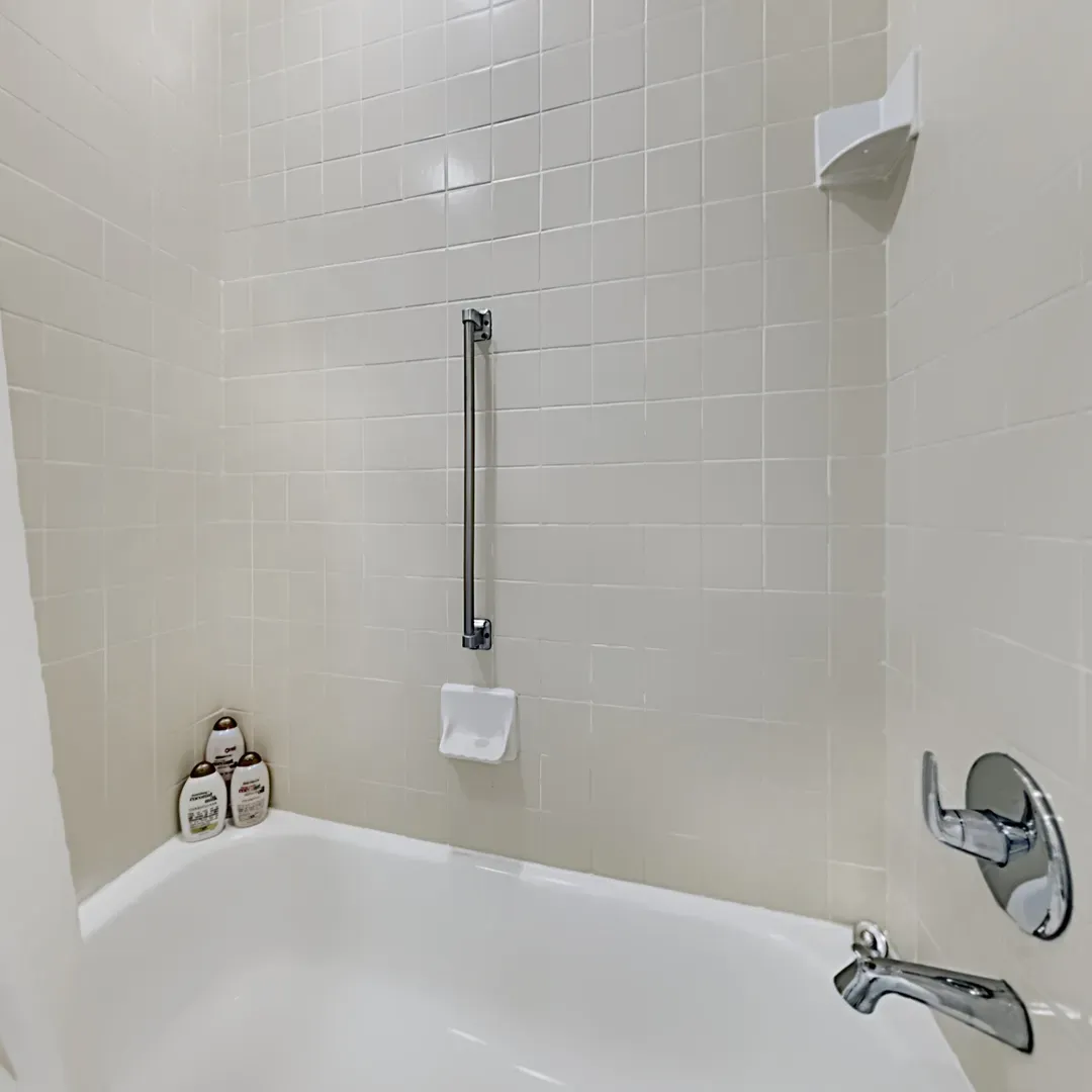 Experience the bathroom with a bathtub and shower combo, providing comfort during your stay.