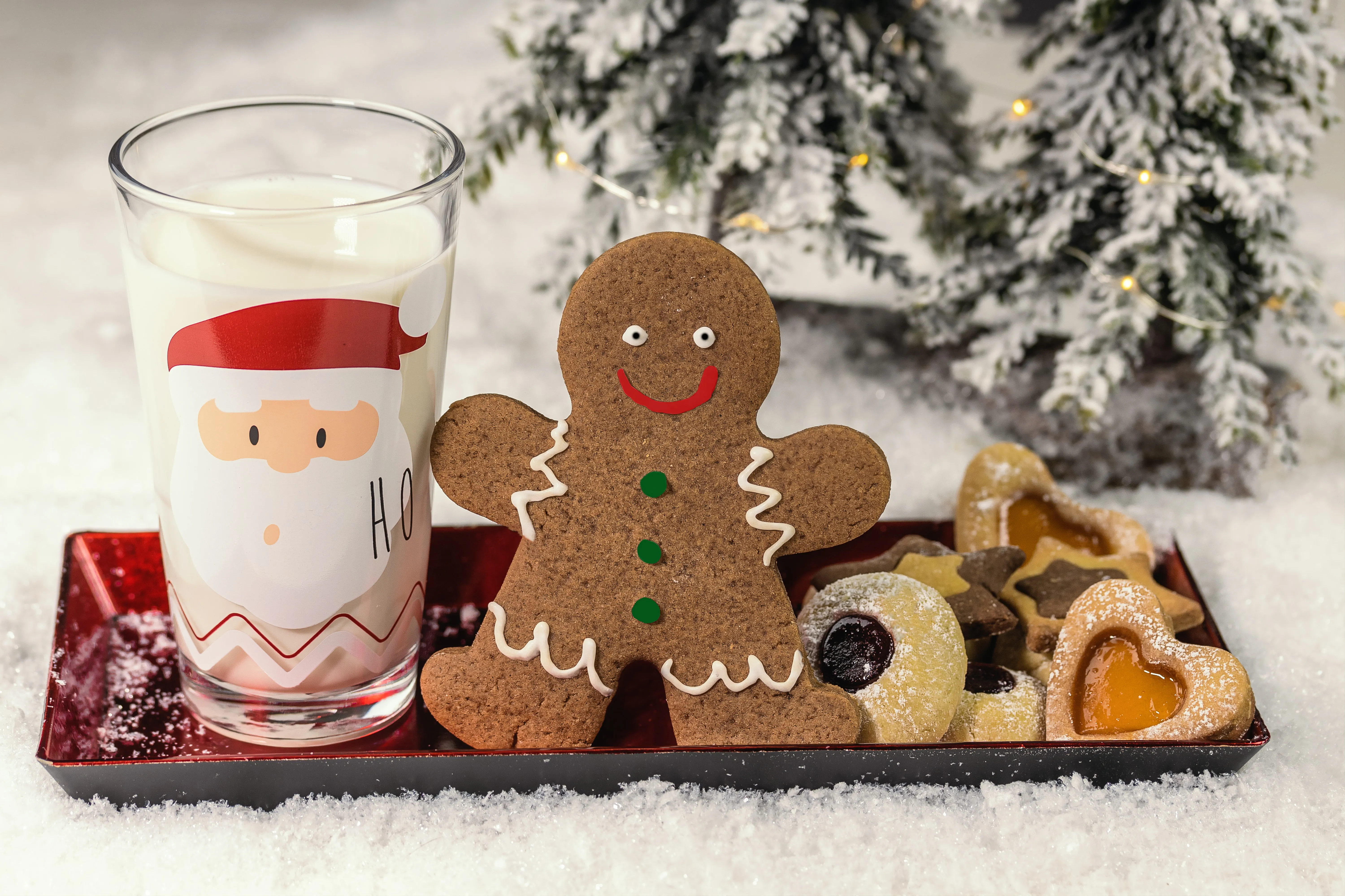 plate of Christmas cookies with a gingerbread man and a glass of milk