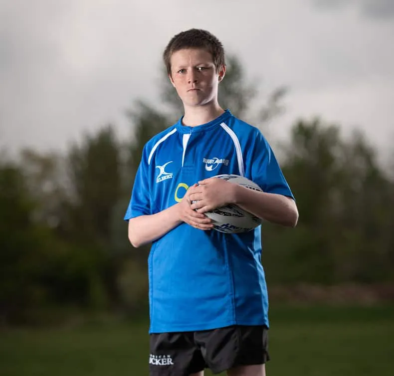 youth rugby player holding ball