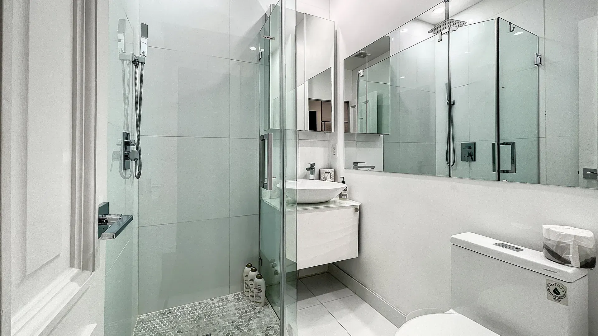 Modern bathrooms with dimmer lights, double sink vanities, shower, bath tub and double mirror wall cabinets