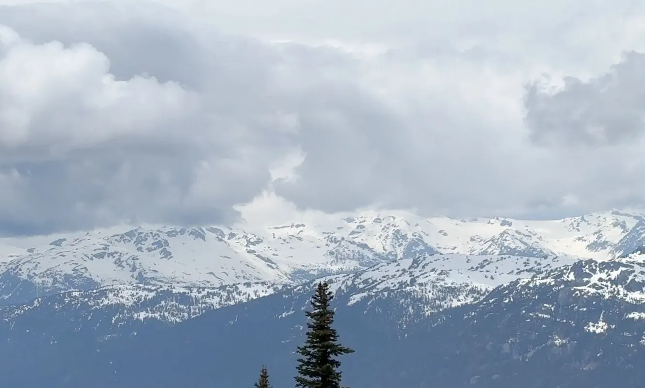 Snow-covered Coast Mountains under dramatic clouds, seen from Whistler