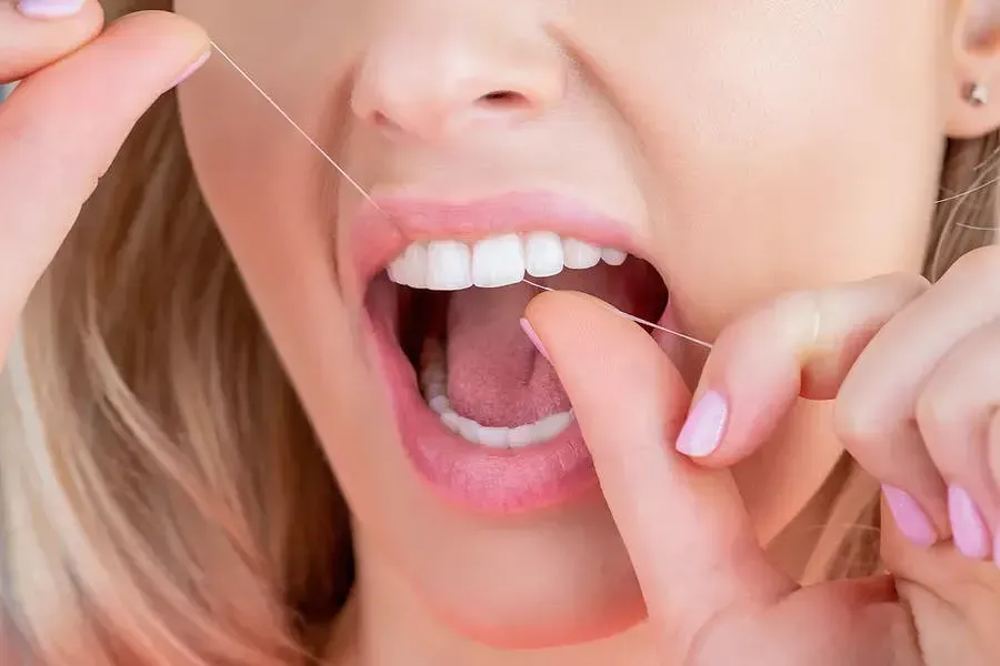 a close-up of a woman flossing.