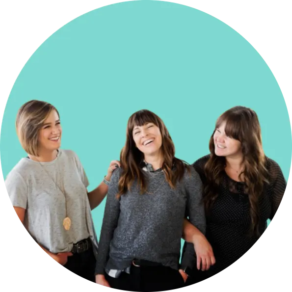 3 women in front of a light blue background happy and laughing because they are excited about their dna test results