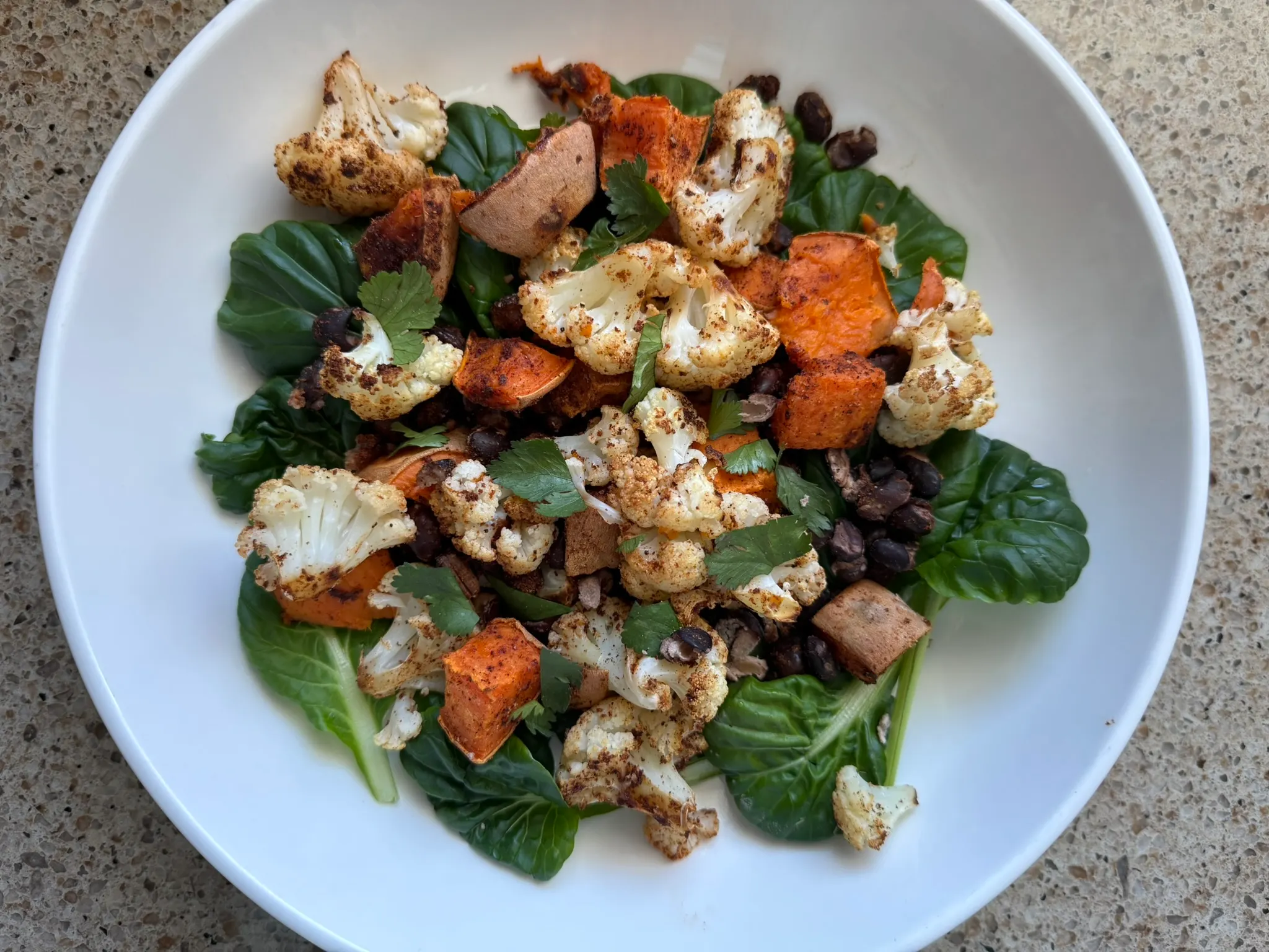 Simple plant-based sheet pan meal with roasted vegetables and beans served in a bowl