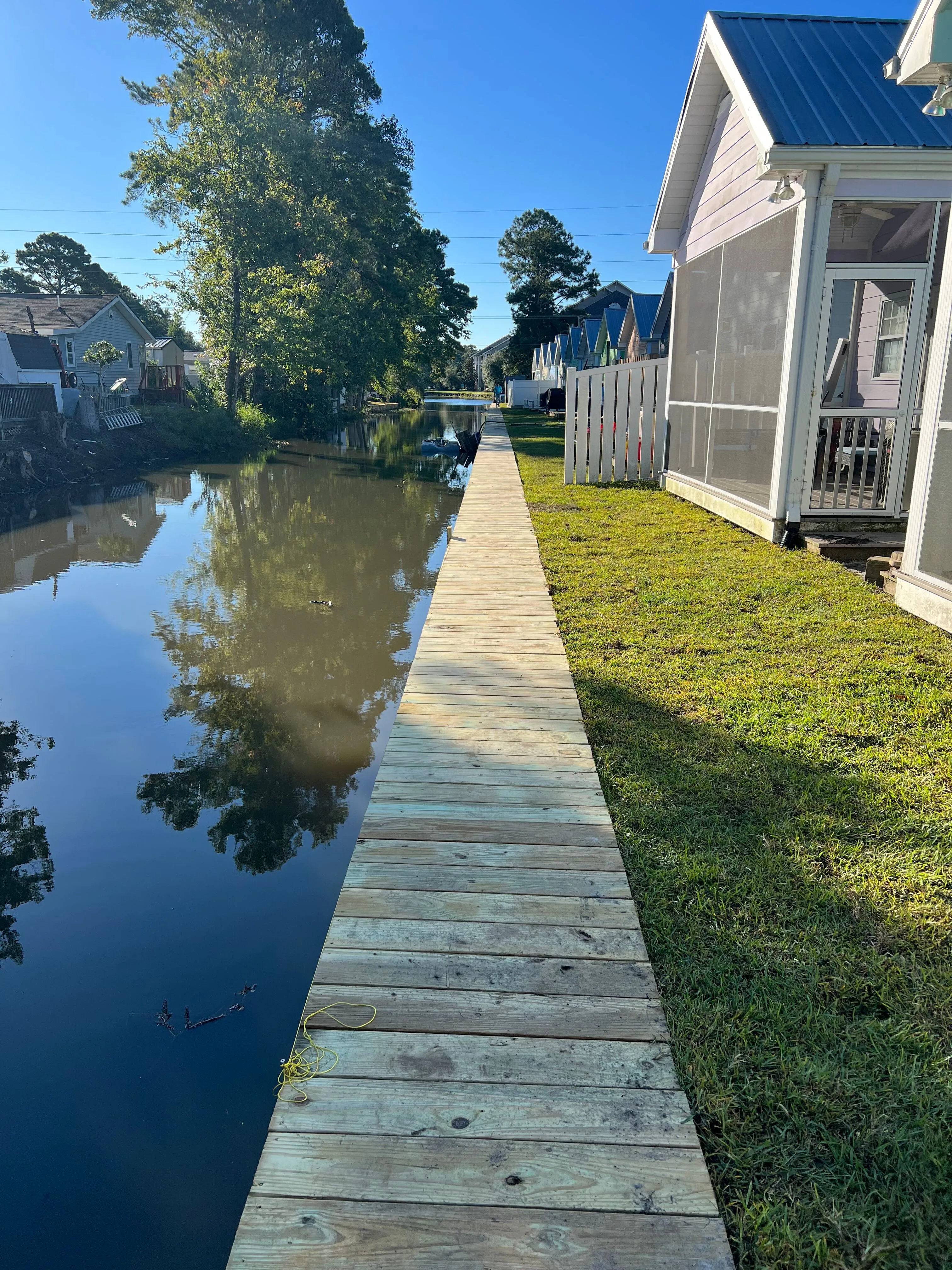 Vinyl Bulkhead with wood cap in Garden City Beach SC on a retention pond built by Waterbridge Contractors of the Carolinas