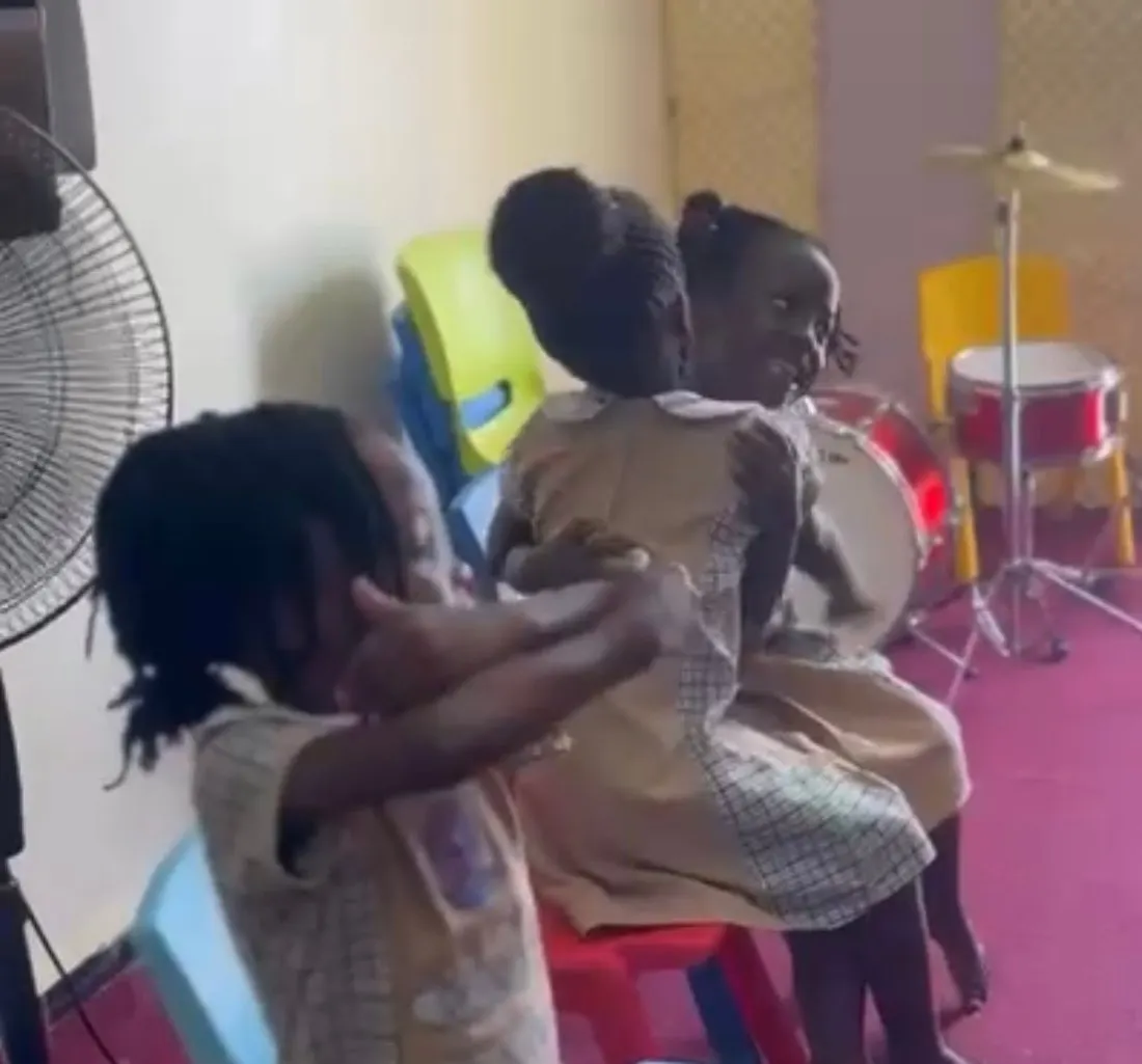 Children at a music school in Kampala giving themselves a hug during a guided mindfulness practice