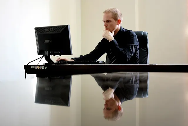 Man thinking while working on computer at a desk