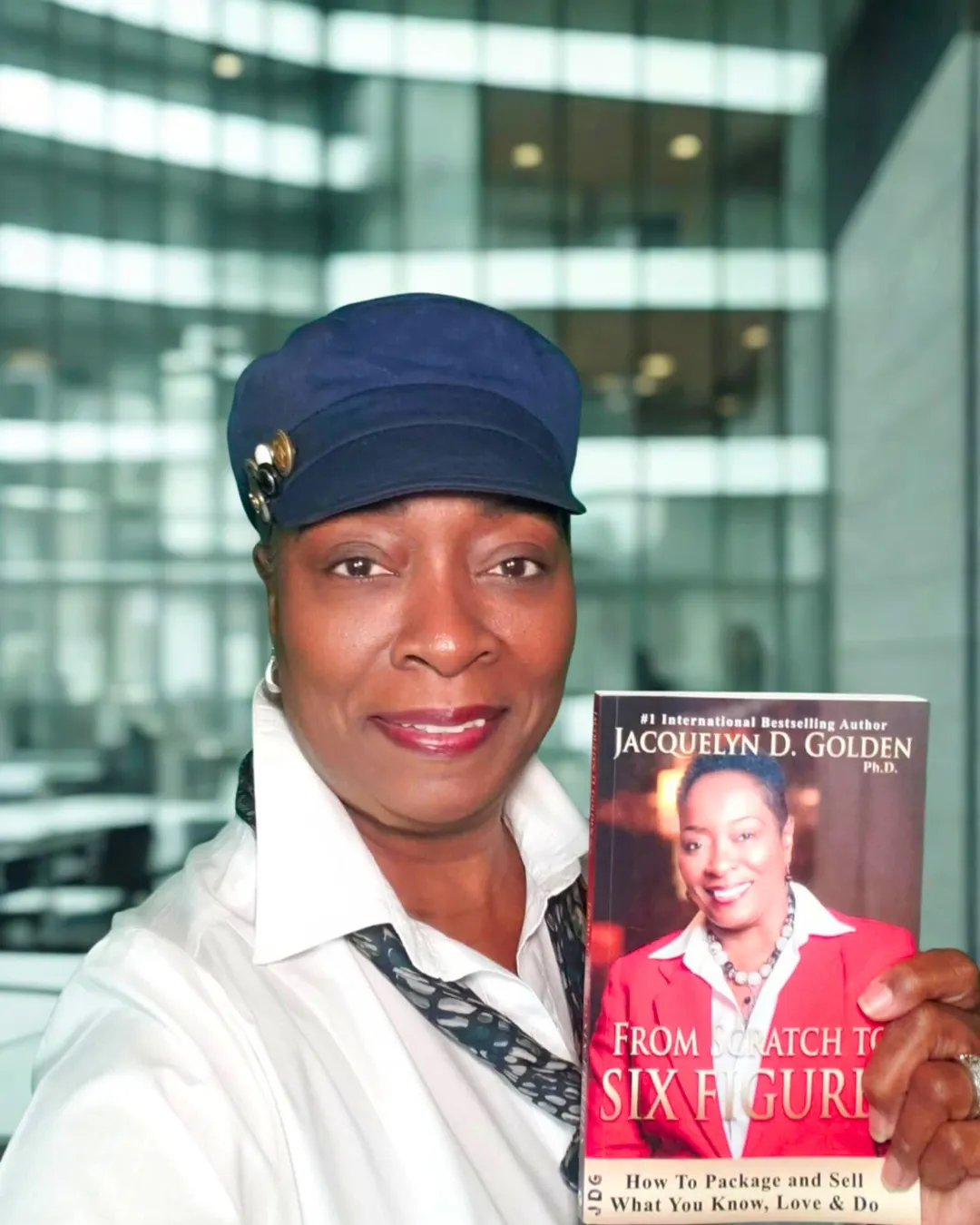 Jackie Golden holding her bestselling book From Scratch to Six Figures