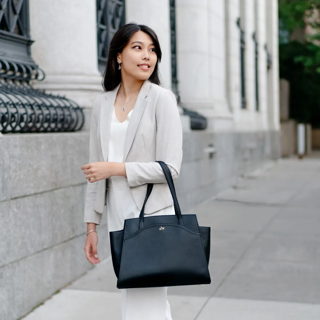 An elegant lady is wearing a black Tang Dynasty Grace Tote, a bag that is inspired by Tang Dynasty, designed by Shen Yun Collections, made in Spain. 