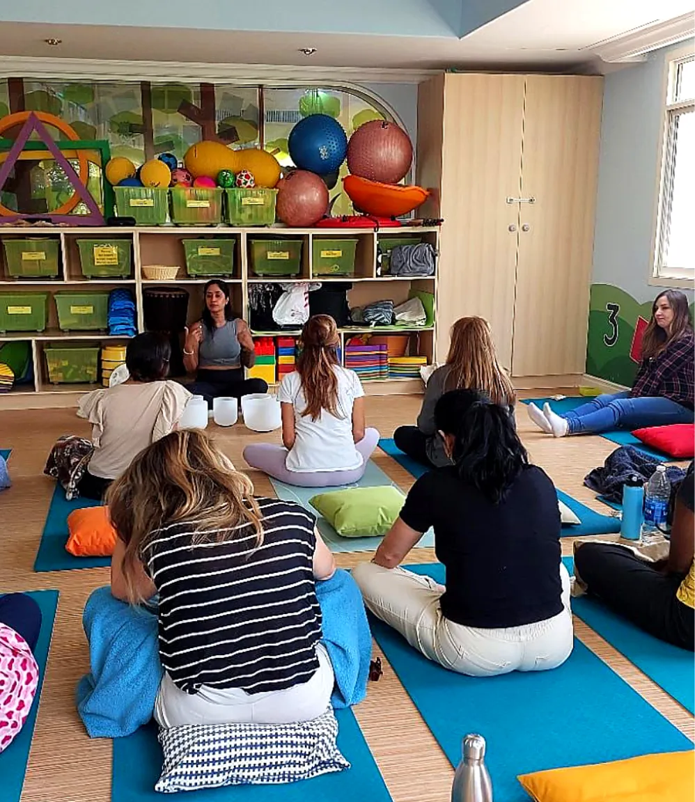 Corporate group participating in a sound healing session with singing bowls for relaxation and stress relief