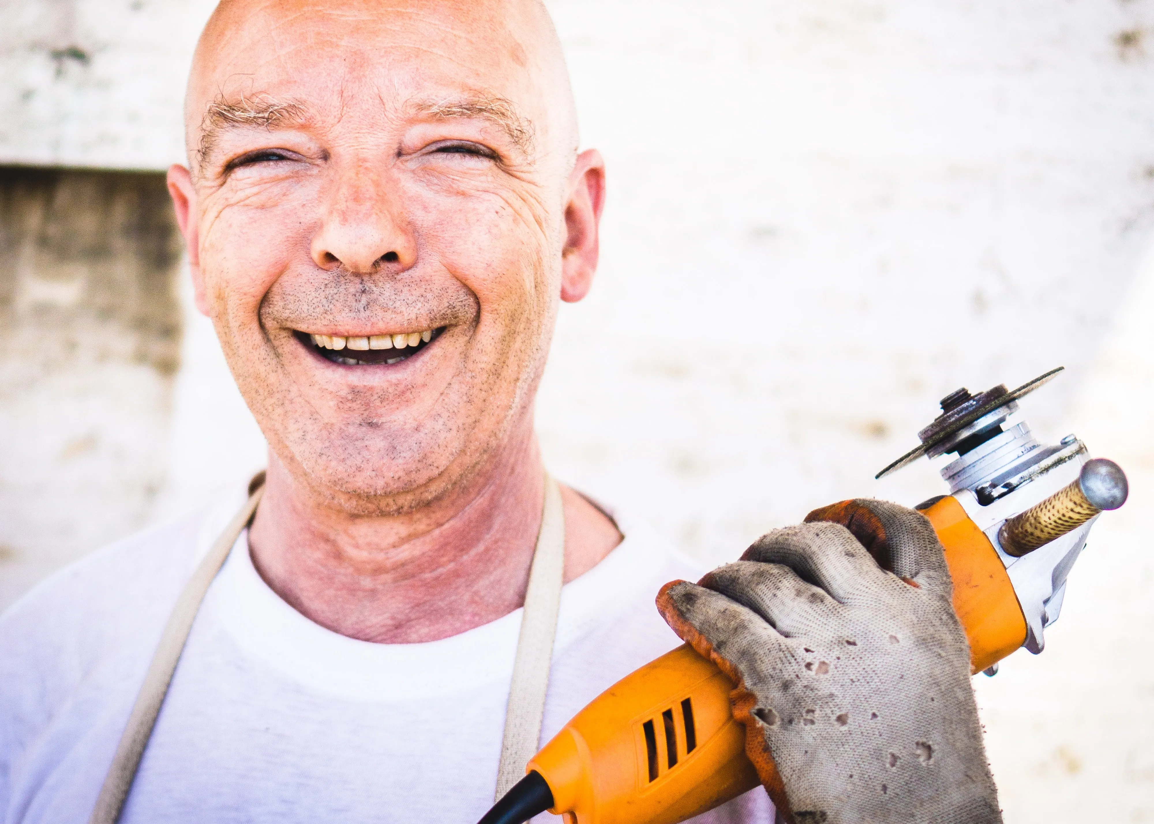 smiling older man with power drill