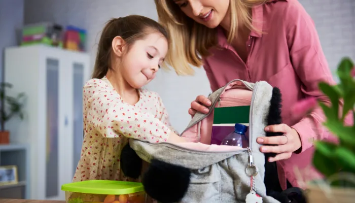 A mom and daughter packing lunch for school.