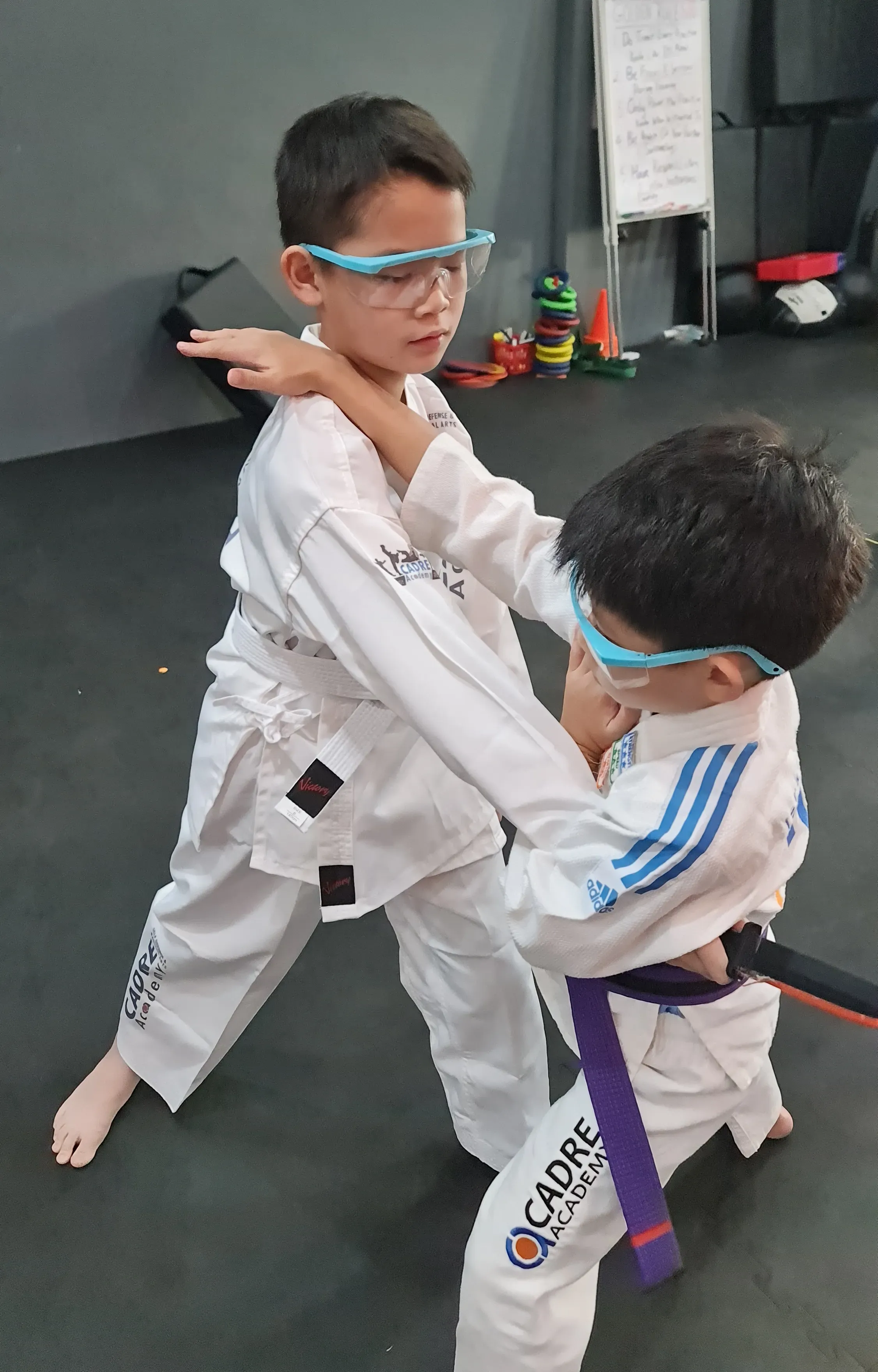 Children practising close-range grappling and control during Integrated Jiujitsu training at CADRE Academy.
