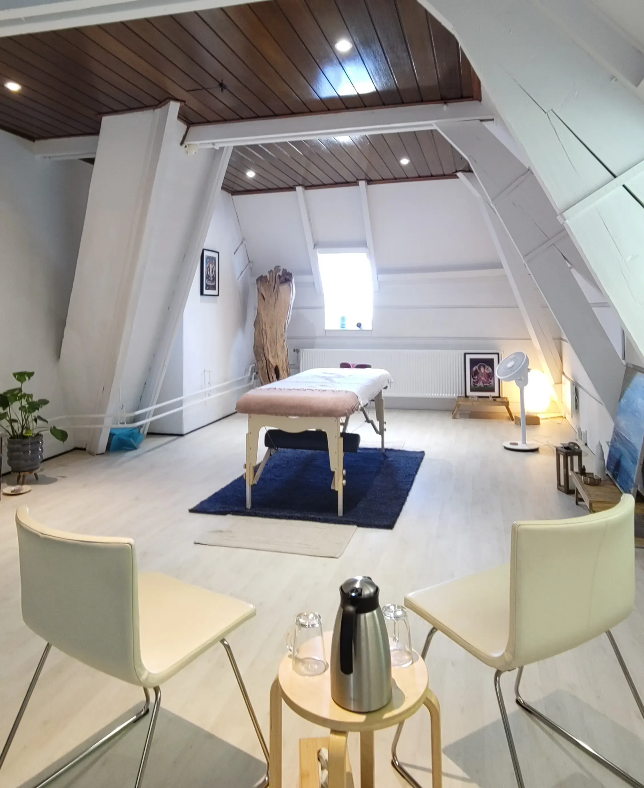 praktijkruimte met massagetafel en stoelen