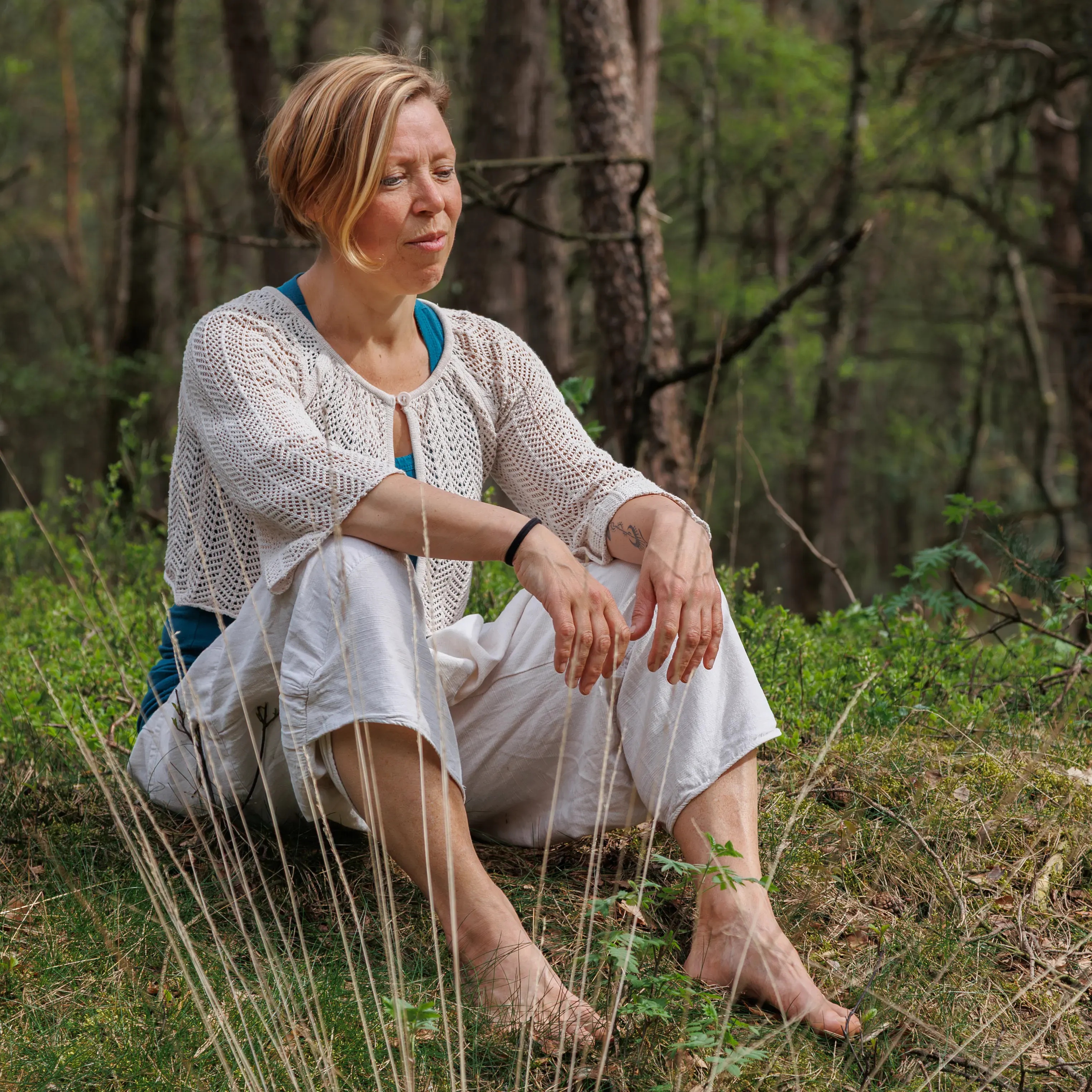 Ingrid zit in het bos met haar aandacht naar binnen gekeerd