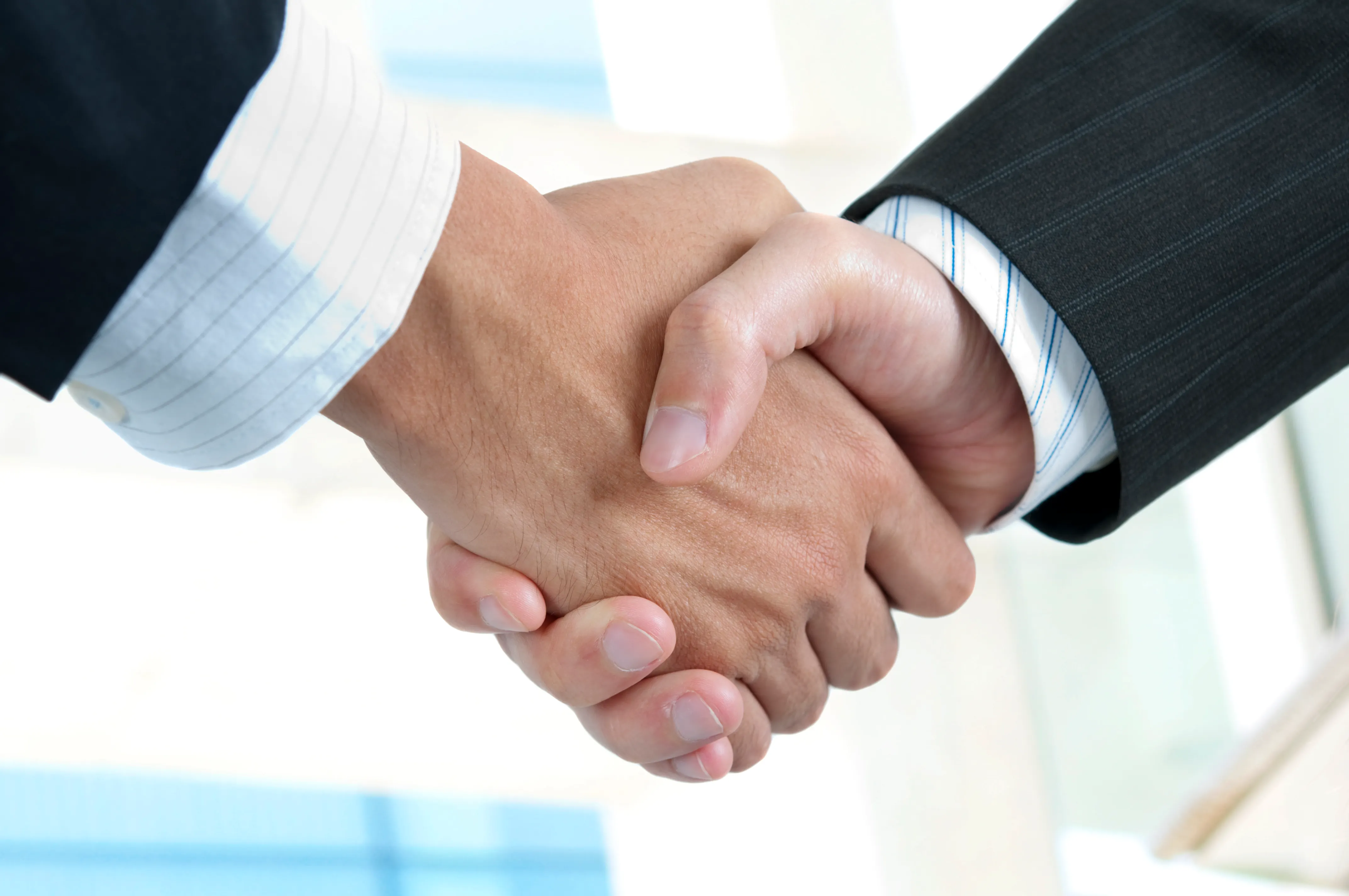 Close-up of a handshake symbolizing a successful land sale agreement.