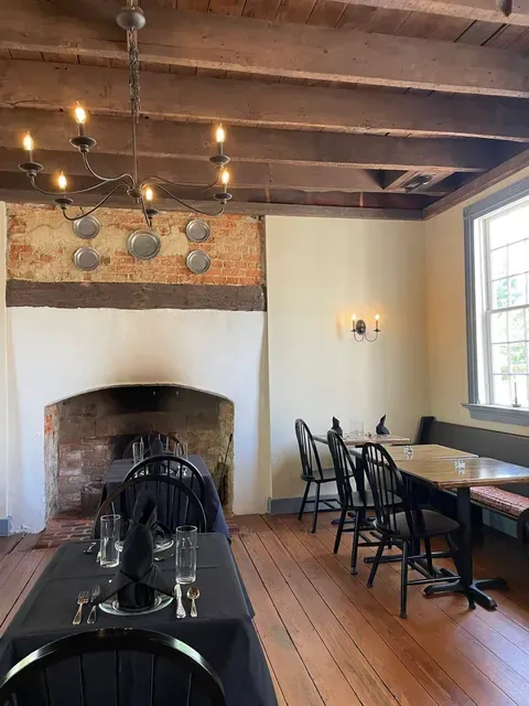 dining room of the 1710 Tavern in Tappahannock Virginia with original floorboards, window glass, and chimney