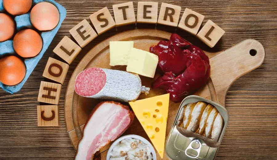 High cholesterol foods on a counter top. Processed meats, eggs, cheese.