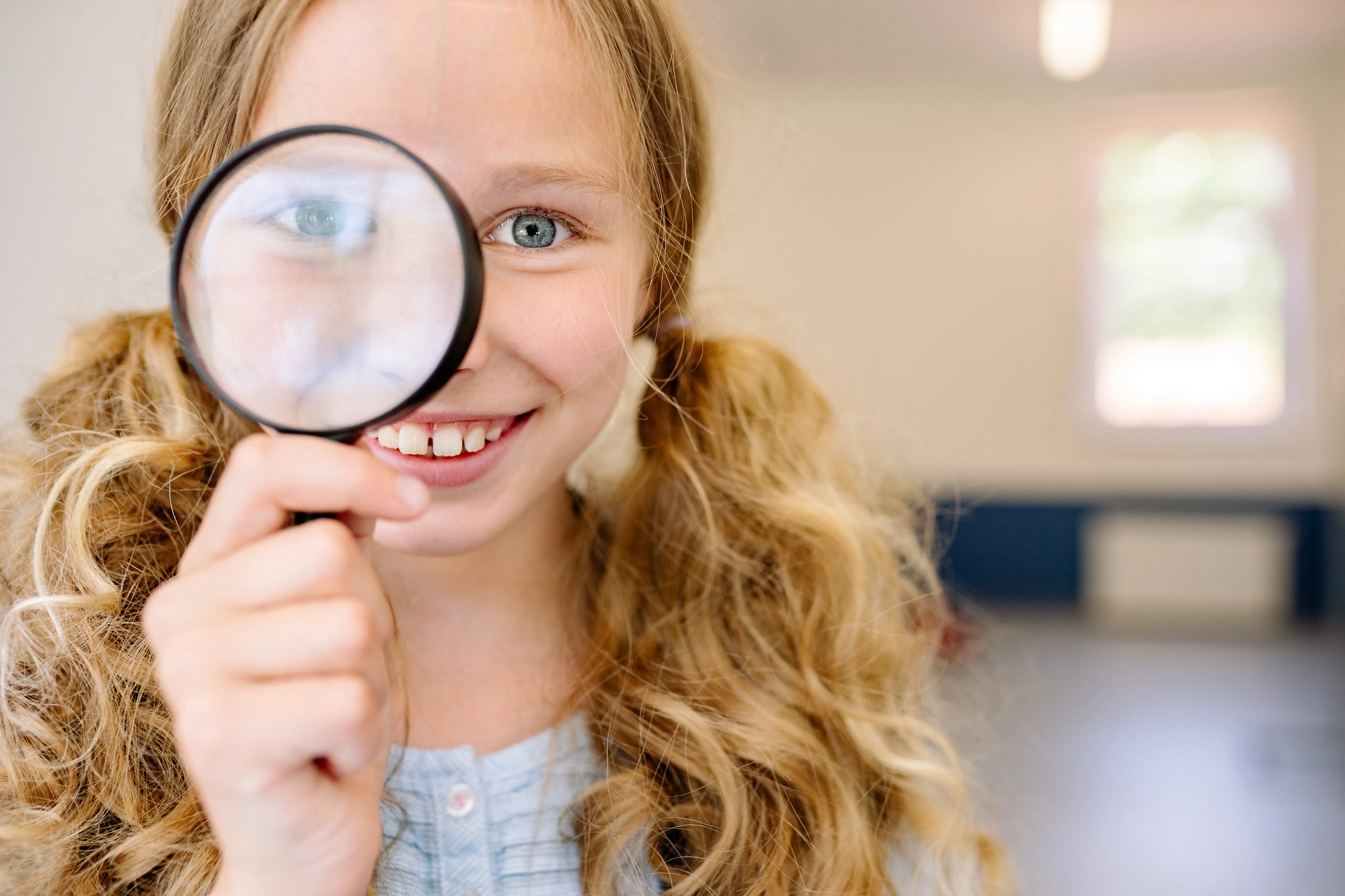 Girl looking through magnifying glass