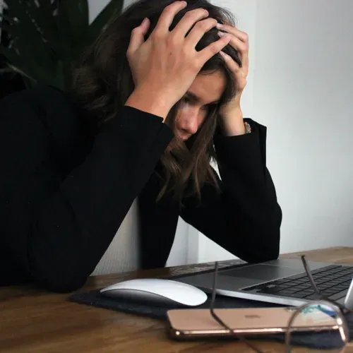 A Woman With Her Hands on Her Head, Stressing Over Her Laptop