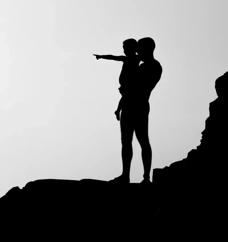 father pointing outward, holding son