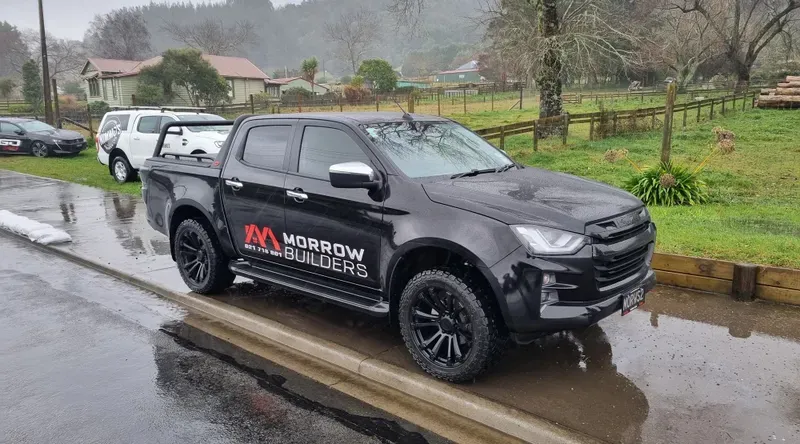 A black Isuzu D-Max pickup truck branded with 