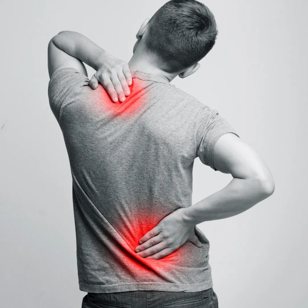 Image of a man holding his neck and back because he is in pain