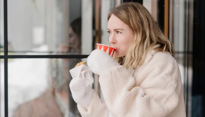 A woman drinking a latte after her mom life coaching session.