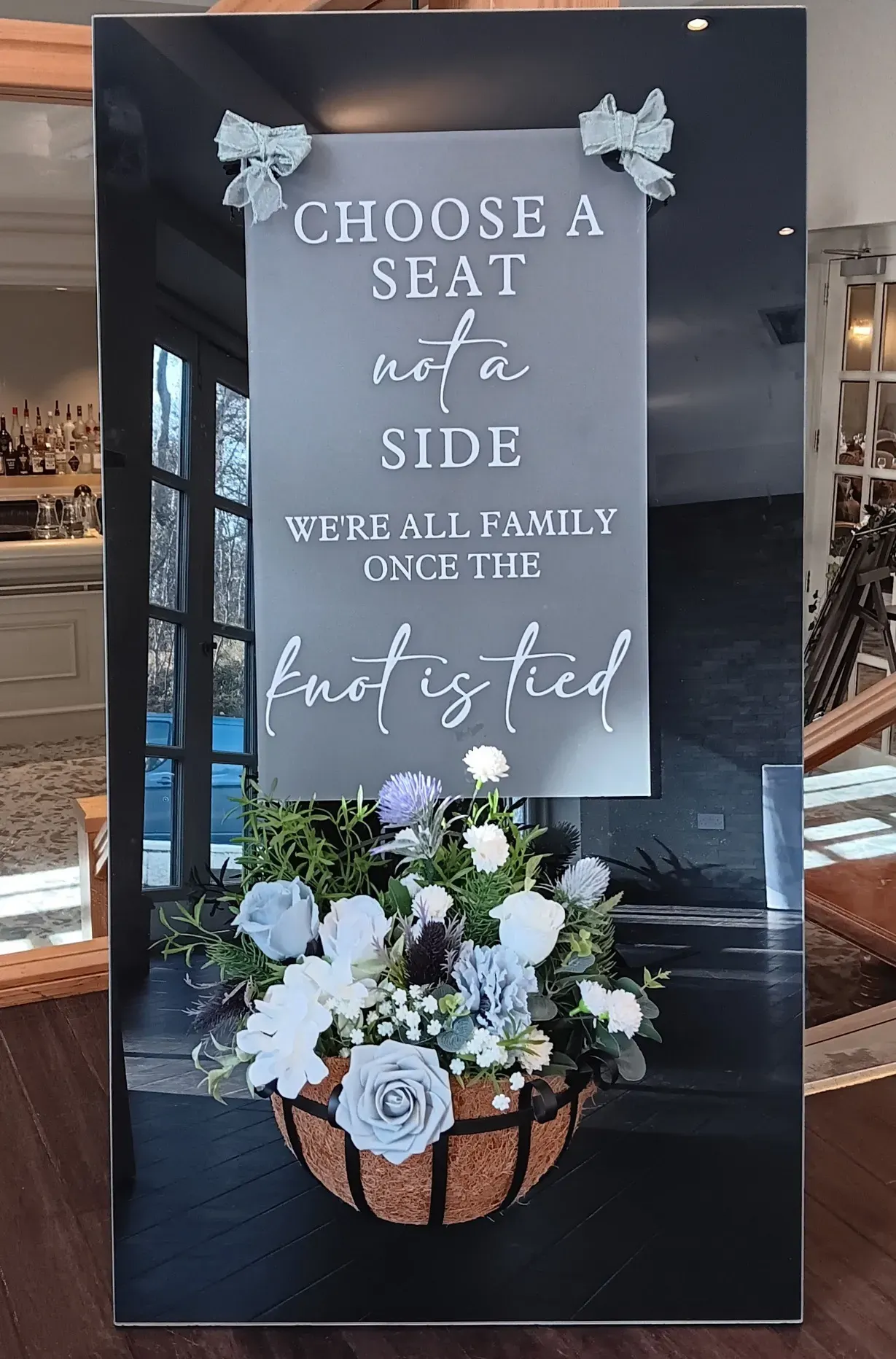 wedding seat poem on black stand decorated with bespoke flower basket