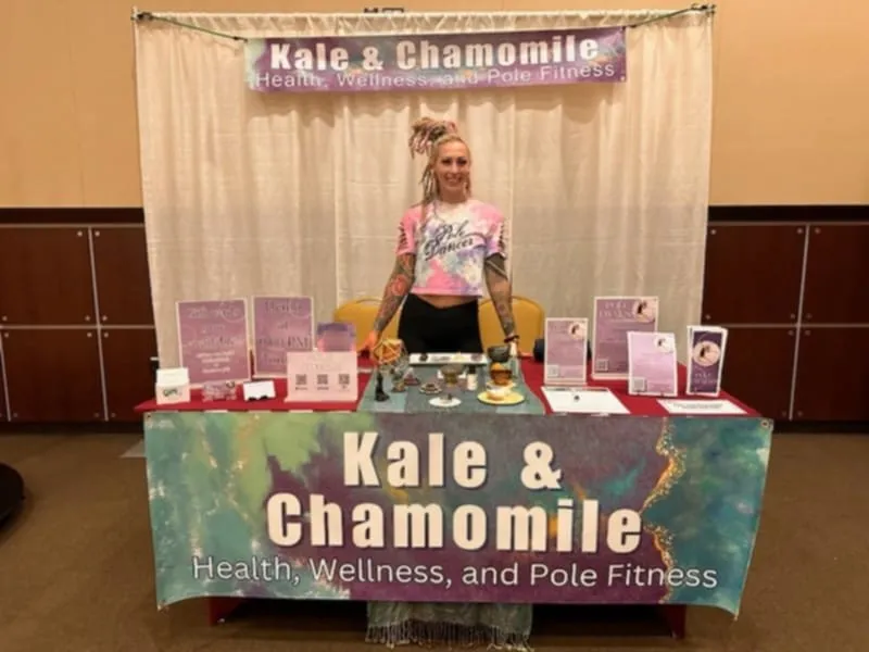 Amanda at her Kale & Chamomile Health, Wellness, and Pole Fitness booth at an expo. 