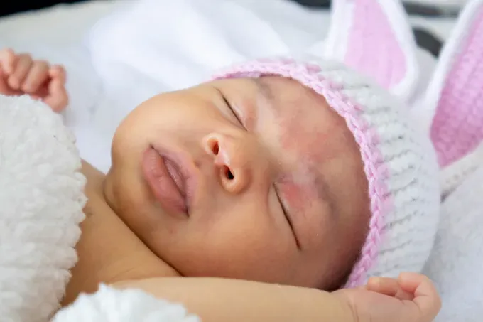 Baby gently sleeping on a soft, cushioned surface