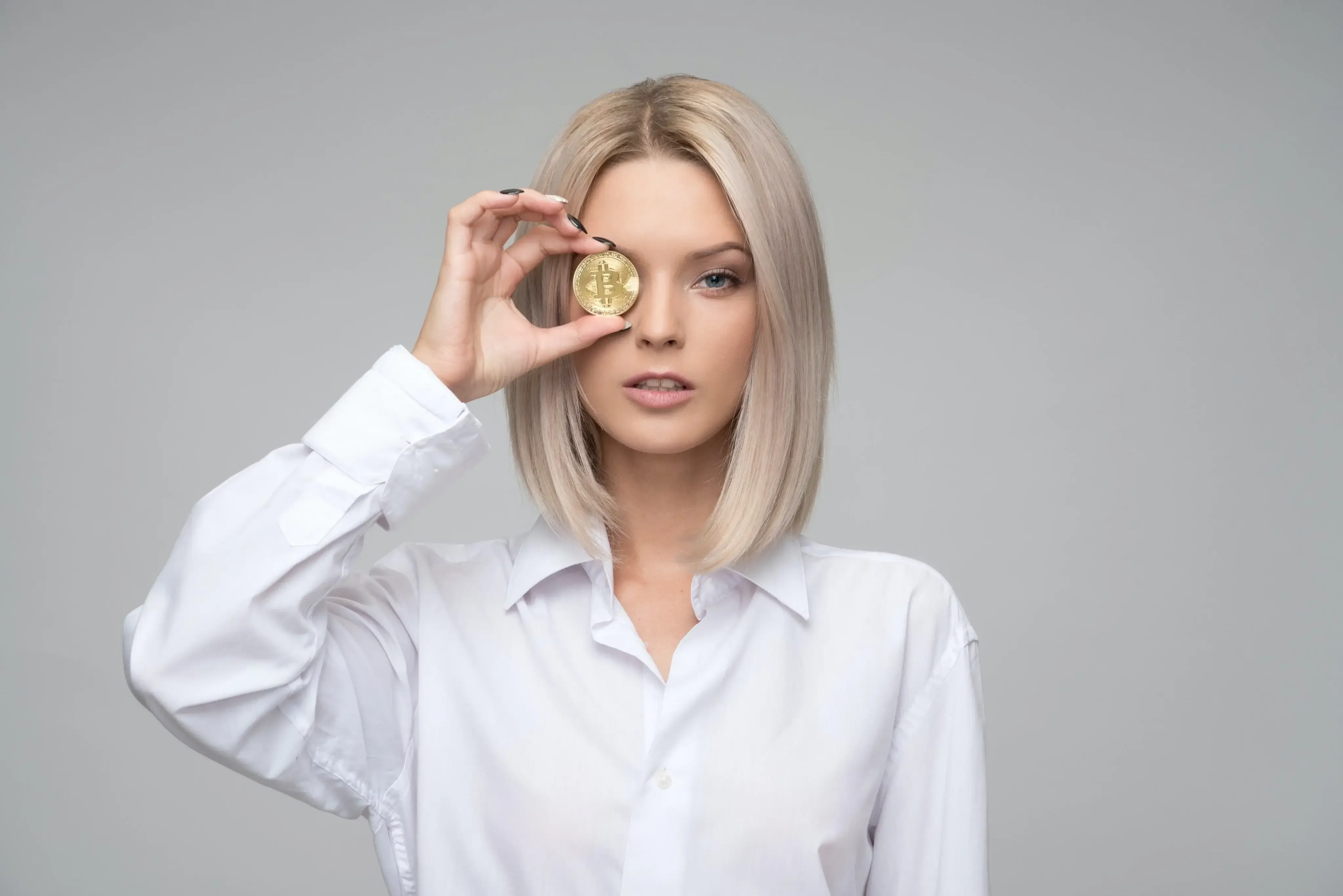woman using a gold coin as an eye glass 