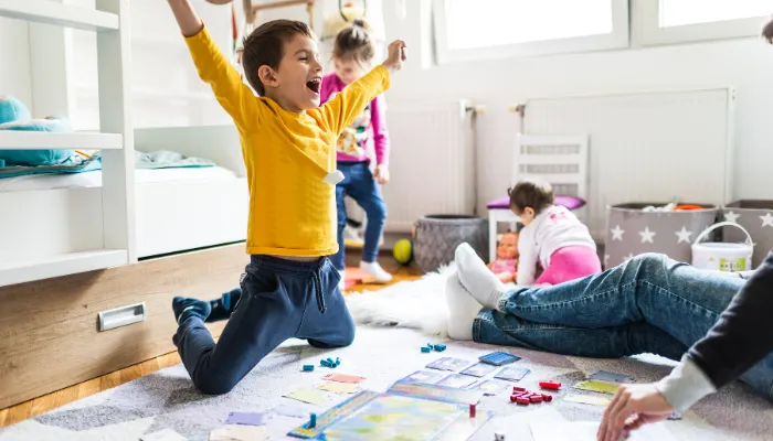 A kid being really happy playing board games with his mom