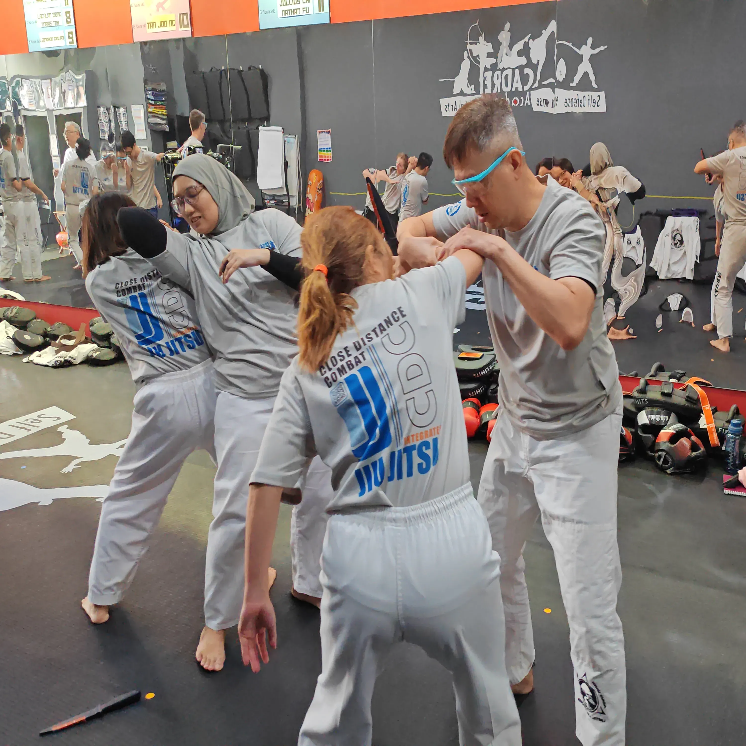 Adults practising Integrated Jiujitsu with partner resistance during training at CADRE Academy.