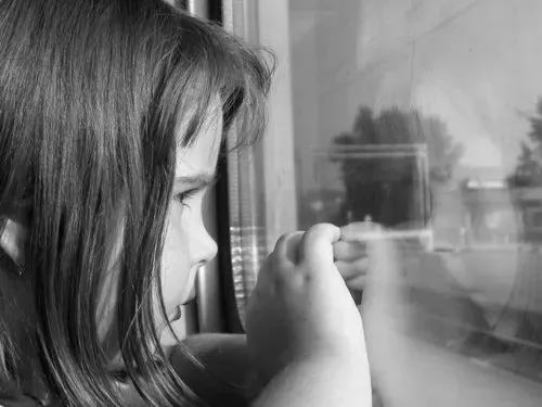 Little Girl Looking Out Side a Window
