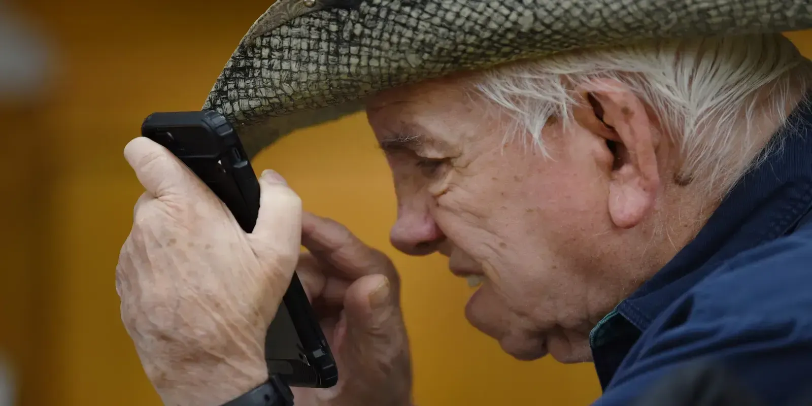 elderly man with difficulty seeing content on phone