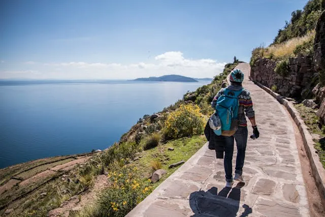 Person walking on path by over water