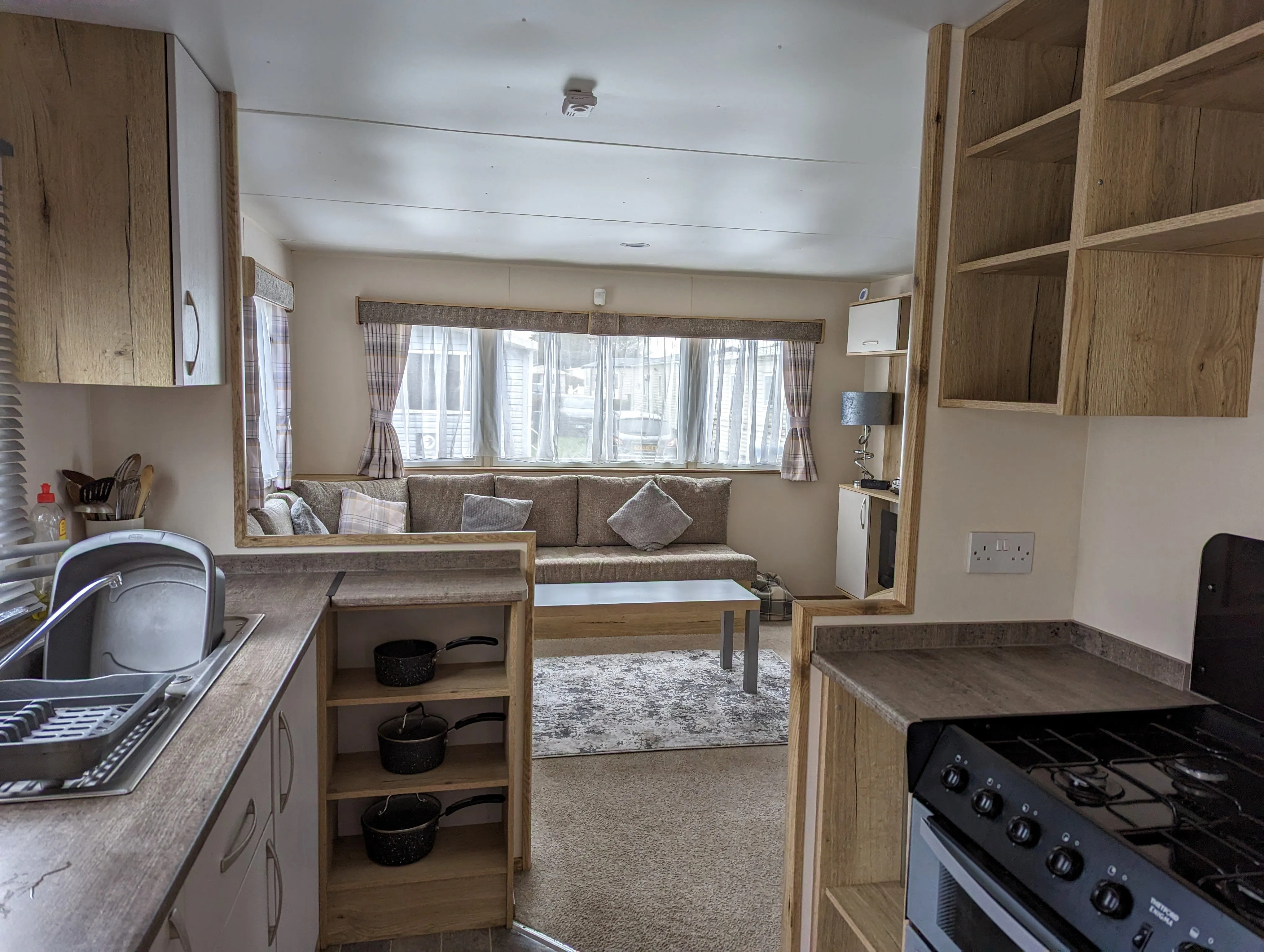 Spacious and modern caravan interior with comfortable seating, dining area, and fully-equipped kitchen