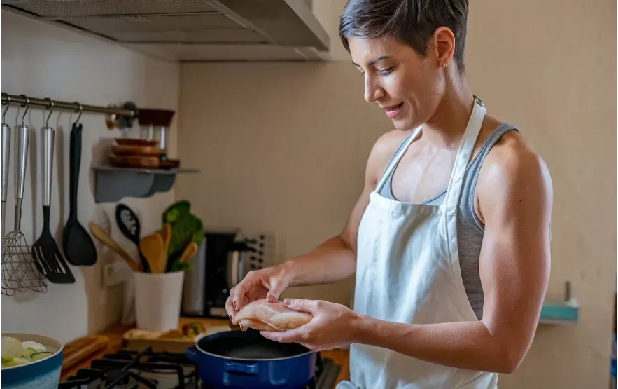 Person preparing a balanced, protein-rich meal for fat loss.