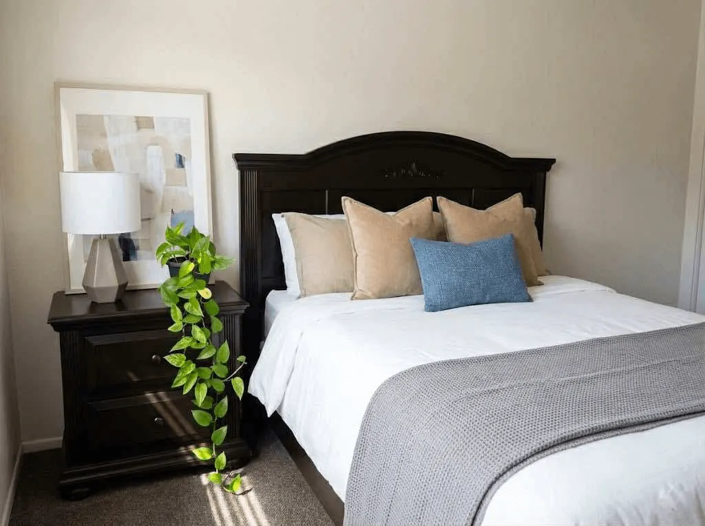 <alt=“Modern furnished bedroom at AHA Global Holdings corporate housing in Ann Arbor, featuring stylish bedding, neutral tones, and contemporary decor.”>