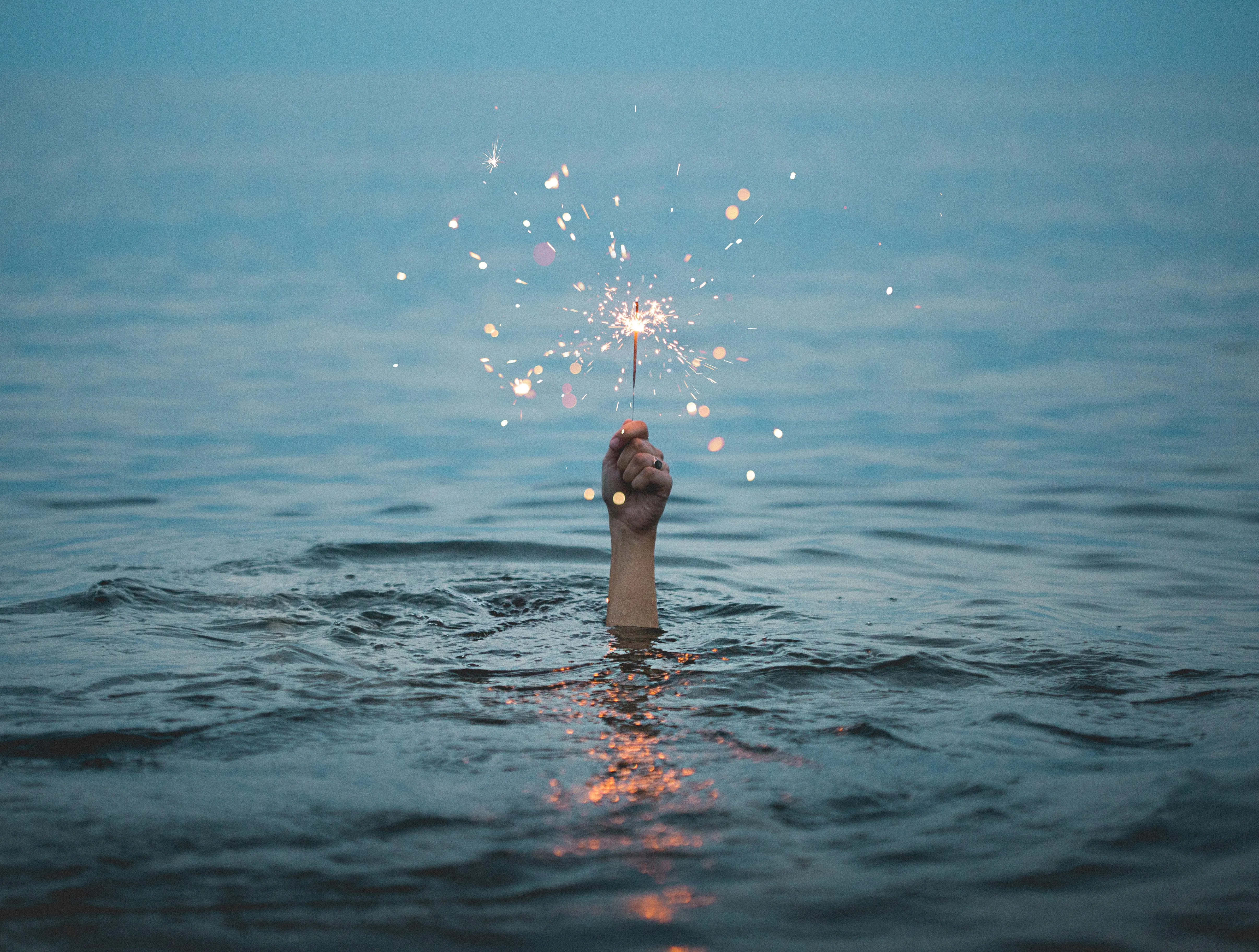 Hand with a sparkler coming out of the water