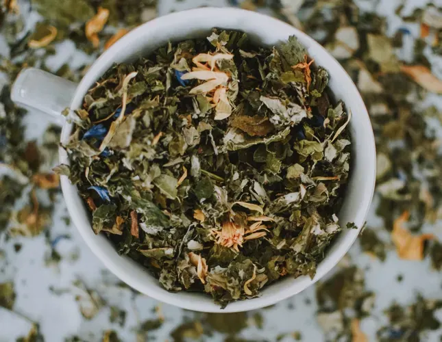 mug filled with loose tea leaves and herbs.