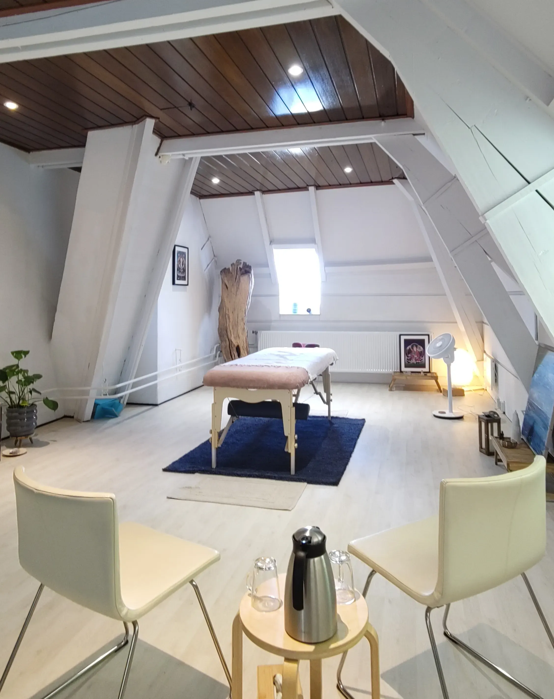 praktijkruimte met massagetafel en stoelen