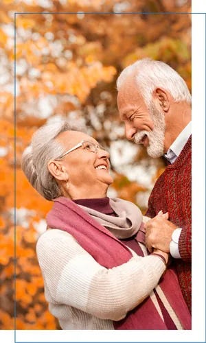 Older couple embracing in the fall leaves